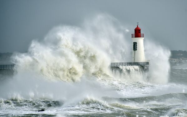 Waves break against a pier and a lighthouse in Les Sables-d'Olonne, western France. - Sputnik International