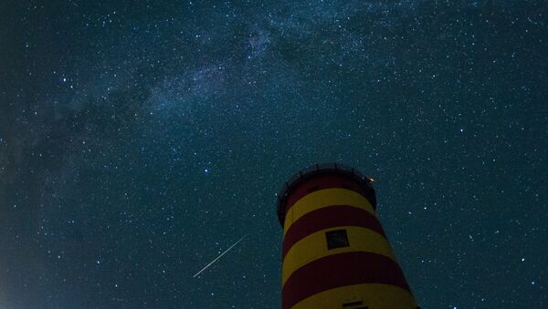 A falling star crosses the night sky behind the lighthouse in Pilsum, northwestern Germany - Sputnik International