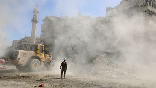A Civil Defence member stands as a front loader removes debris after an air strike Sunday in the rebel-held besieged al-Qaterji neighbourhood of Aleppo, Syria October 17, 2016. - Sputnik International