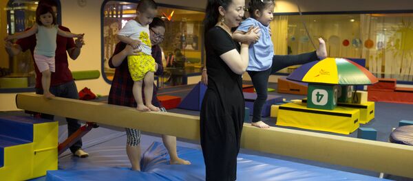 Children are guided by their parents during classes at the Inspire Sports private gym in Shanghai, China. (File) Children are guided by their parents during classes at the Inspire Sports private gym in Shanghai, China. (File) - Sputnik International