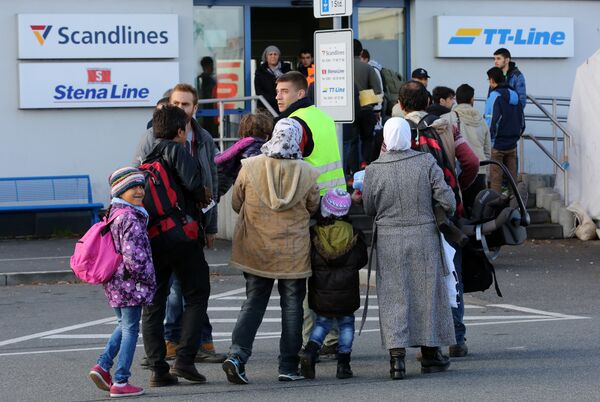 Migrants go to the ferry terminal to buy tickets at the port of Rostock, northeastern Germany Migrants go to the ferry terminal to buy tickets at the port of Rostock, northeastern Germany - Sputnik International