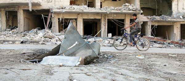 A man rides a bicycle near damaged ground in the rebel held besieged al-Sukkari neighbourhood of Aleppo, Syria October 19, 2016. - Sputnik International