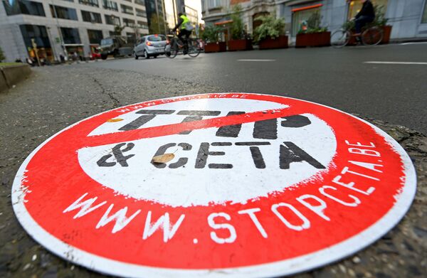 A cyclist rides past a placard reading STOP TTIP CETA outside the EU Council headquarters ahead of a European Union leaders summit in Brussels, Belgium October 20, 2016. A cyclist rides past a placard reading STOP TTIP CETA outside the EU Council headquarters ahead of a European Union leaders summit in Brussels, Belgium October 20, 2016. - Sputnik International
