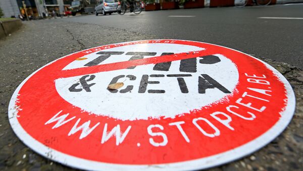 A cyclist rides past a placard reading  STOP TTIP CETA outside the EU Council headquarters ahead of a European Union leaders summit in Brussels, Belgium October 20, 2016. - Sputnik International