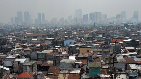 This general view shows informal settlers' homes (foreground) dwarped by highrise buildings in the background near the port of Manila - Sputnik International