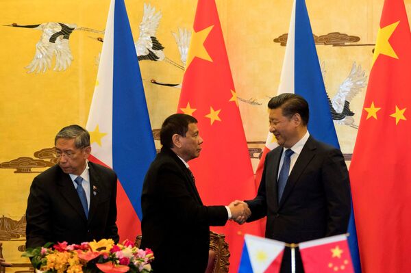 Philippine President Rodrigo Duterte and Chinese President Xi Jinping (R) shake hands after a signing ceremony held in Beijing, China, October 20, 2016 Philippine President Rodrigo Duterte and Chinese President Xi Jinping (R) shake hands after a signing ceremony held in Beijing, China, October 20, 2016 - Sputnik International
