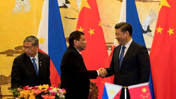 Philippine President Rodrigo Duterte and Chinese President Xi Jinping (R) shake hands after a signing ceremony held in Beijing, China, October 20, 2016 - Sputnik International