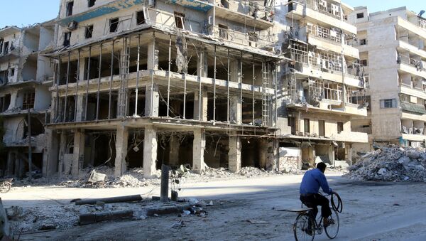 A man rides a bicycle near damaged buildings in the rebel held besieged al-Sukkari neighbourhood of Aleppo, Syria. (File) - Sputnik International