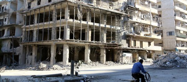 A man rides a bicycle near damaged buildings in the rebel held besieged al-Sukkari neighbourhood of Aleppo, Syria. (File) A man rides a bicycle near damaged buildings in the rebel held besieged al-Sukkari neighbourhood of Aleppo, Syria. (File) - Sputnik International