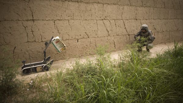 A bomb disposal robot brings a carton for inspection by US Army bomb disposal expert Staff Sergeant Craig Cohen, of Gracey, Kentucky, during clearance operations by the 723rd Explosives Ordinance Disposal unit near COP Nolen, in the volatile Arghandab Valley, Kandahar, Afghanistan, Friday, July 23, 2010. - Sputnik International