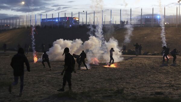 French riot police officers fire tear gas canisters during clashes with migrants in a makeshift migrant camp near Calais, France, Saturday, Oct. 22, 2016 - Sputnik International