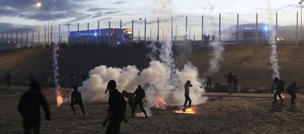 French riot police officers fire tear gas canisters during clashes with migrants in a makeshift migrant camp near Calais, France, Saturday, Oct. 22, 2016 French riot police officers fire tear gas canisters during clashes with migrants in a makeshift migrant camp near Calais, France, Saturday, Oct. 22, 2016 - Sputnik International