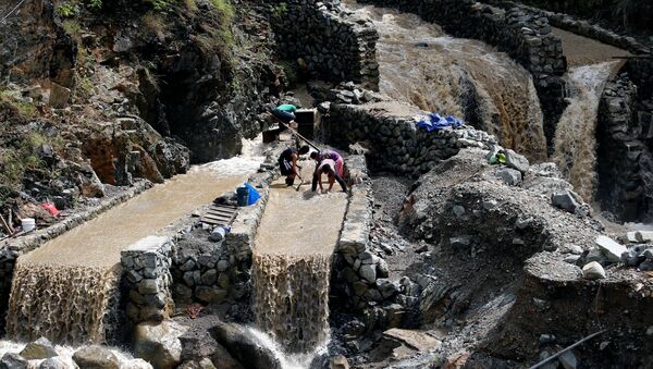 Local miners collect small rocks, as they mine for gold, from the waters that come from the mountains a day after Typhoon Haima struck Benguet province in northern Philippines, October 21, 2016 - Sputnik International