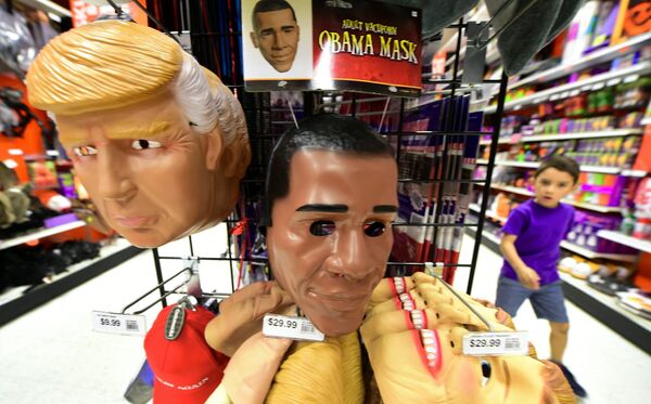 A child walks past a display of masks of US President Barack Obama, and presidential hopefuls Donald Trump and Hillary Clinton, for sale at a shop selling Halloween items in Alhambra, California on October 21, 2016 - Sputnik International