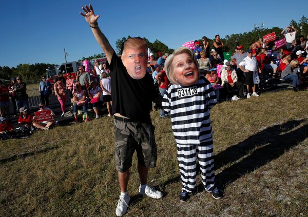 Craig Wendel dresses as Republican U.S. presidential nominee Donald Trump and his wife Jill Wendel wears a Hillary Clinton mask as they support Trump at a campaign rally in Naples, Florida, U.S. October 23, 2016 - Sputnik International