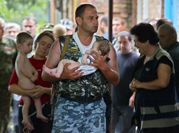 A Special Forces soldier carries a baby after a school was liberated from militants in Beslan, North Ossetia. The Beslan school siege started on September 1, 2004, and lasted three days. Over 1,100 people were taken hostage, including 777 children; at least 385 people died in Russia's worst ever terrorist attack. - Sputnik International