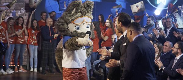 FIFA 2018 World Cup Russia official mascot, the wolf named Zabivaka, center, shakes hands with Vitaly Mutko, deputy premiership in charge of sport, tourism and youth policies, Alexey Sorokin, CEO of the 2018 FIFA World Cup Russia Local Organizing Committee, all back to a camera, during a TV show on Russian Channel 1 in Moscow, Russia, Saturday, Oct. 22, 2016 - Sputnik International