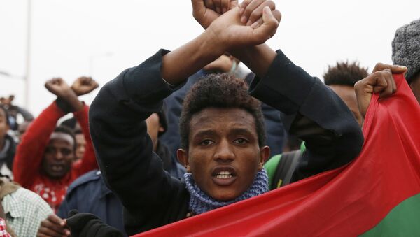 Ethiopian migrants, members of the Oromo community, react as they leave the Jungle to be transfered to reception centers during the start of the dismantlement of the camp in Calais, France, October 24, 2016. - Sputnik International