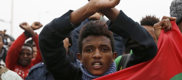 Ethiopian migrants, members of the Oromo community, react as they leave the Jungle to be transfered to reception centers during the start of the dismantlement of the camp in Calais, France, October 24, 2016. - Sputnik International