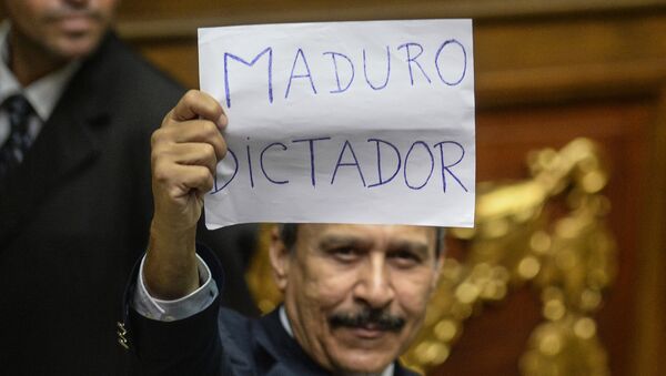 A Venezuelan opposition deputy holds up a sing reading  Maduro dictator during an extraoridinary session of the National Assembly, in Caracas on October 23, 2016 - Sputnik International