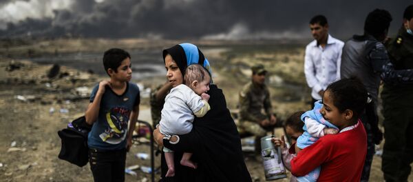 Iraqi families, who were displaced by the ongoing operation by Iraqi forces against jihadistds of the Islamic State group to retake the city of Mosul, are seen gathering on an area near Qayyarah on October 24, 2016 Iraqi families, who were displaced by the ongoing operation by Iraqi forces against jihadistds of the Islamic State group to retake the city of Mosul, are seen gathering on an area near Qayyarah on October 24, 2016 - Sputnik International