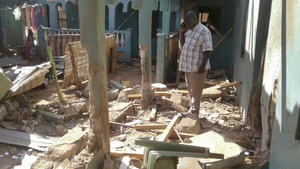 A man stands amid the debris at the scene of an attack in the town of Mandera, Kenya, near the border with Somalia, Tuesday, Oct. 25, 2016 - Sputnik International