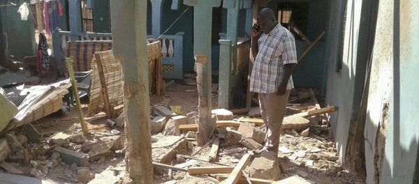 A man stands amid the debris at the scene of an attack in the town of Mandera, Kenya, near the border with Somalia, Tuesday, Oct. 25, 2016 - Sputnik International