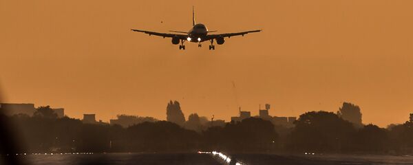 A passenger aircraft prepares to land during sunrise at London Heathrow Airport in west London on October 17, 2016 A passenger aircraft prepares to land during sunrise at London Heathrow Airport in west London on October 17, 2016 - Sputnik International
