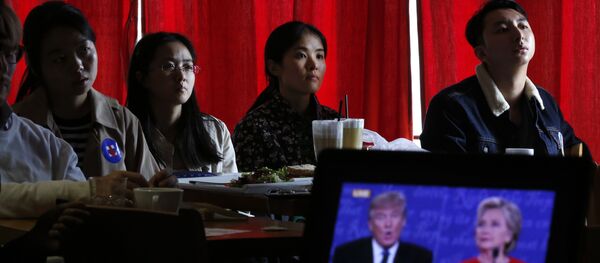 Chinese students watch live broadcasting of the U.S. presidential debate between Democratic presidential nominee Hillary Clinton and Republican presidential nominee Donald Trump, at a cafe in Beijing, Tuesday, Sept. 27, 2016 - Sputnik International