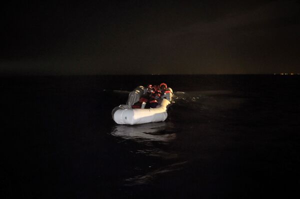 Refugees and migrants wait to be rescued from their sinking rubber boat some eight nautical miles off Libya's Mediterranean coastline on October 12, 2016 Refugees and migrants wait to be rescued from their sinking rubber boat some eight nautical miles off Libya's Mediterranean coastline on October 12, 2016 - Sputnik International
