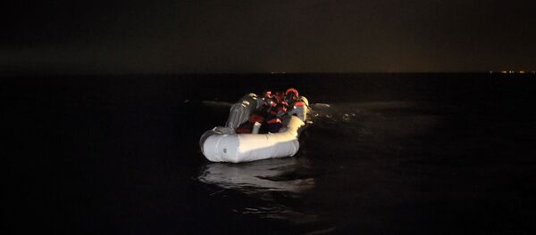 Refugees and migrants wait to be rescued from their sinking rubber boat some eight nautical miles off Libya's Mediterranean coastline on October 12, 2016 - Sputnik International