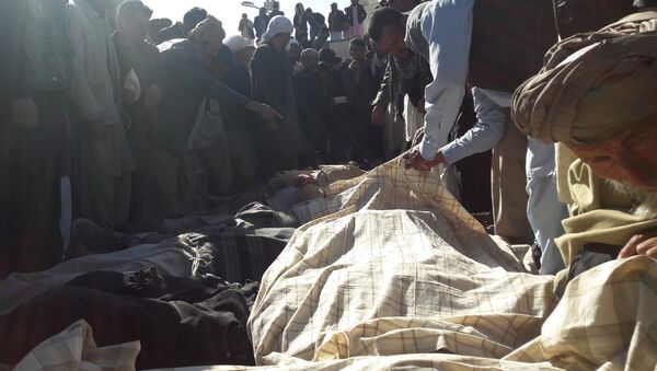 Afghan men gather around the bodies of civilians, including children who were killed by Islamic State militants in Ghor province on October 26, 2016 - Sputnik International