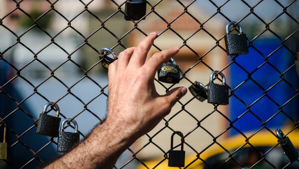 A demonstrator puts his hand on a fence with padlocks left by prisoners during a demonstration in front of the Metris prison on June 24, 2016 in Istanbul. - Sputnik International
