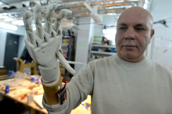 Sergei Galtsev demonstrates how an electromechanical arm prosthetis, made by his son, programmer Oleg, works Sergei Galtsev demonstrates how an electromechanical arm prosthetis, made by his son, programmer Oleg, works - Sputnik International