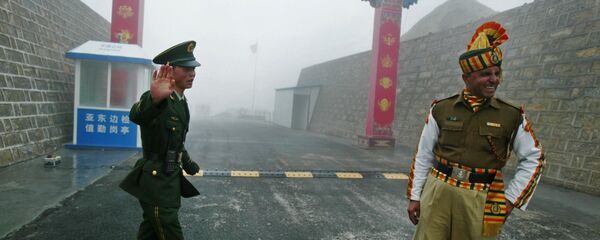 Chinese soldier (L) and an Indian soldier stand guard at the Chinese side of the ancient Nathu La border crossing between India and China. - Sputnik International