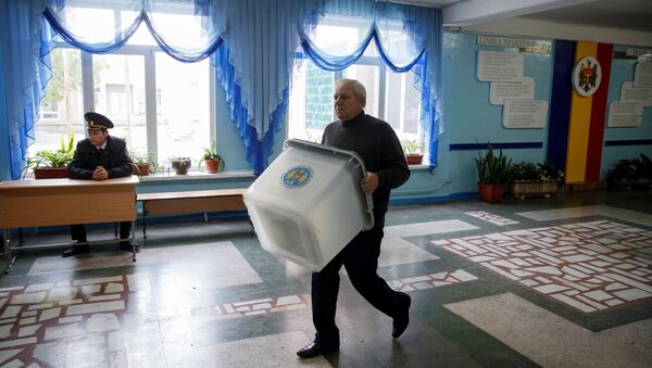 A member of a local electoral commission carries a ballot box at a polling station ahead of the presidential election in Chisinau, Moldova, October 29, 2016. - Sputnik International
