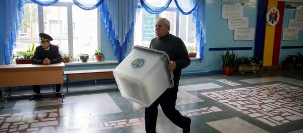 A member of a local electoral commission carries a ballot box at a polling station ahead of the presidential election in Chisinau, Moldova, October 29, 2016. A member of a local electoral commission carries a ballot box at a polling station ahead of the presidential election in Chisinau, Moldova, October 29, 2016. - Sputnik International