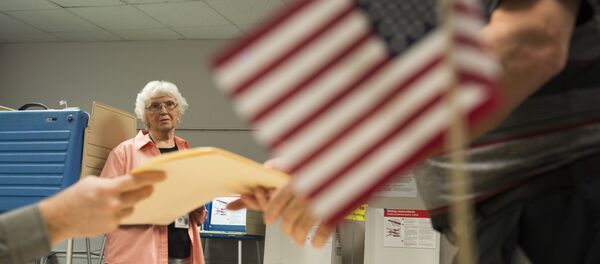 An election official watches as a man takes a ballot at an in-person absentee voting station in Fairfax, Virginia on October 12, 2016 An election official watches as a man takes a ballot at an in-person absentee voting station in Fairfax, Virginia on October 12, 2016 - Sputnik International