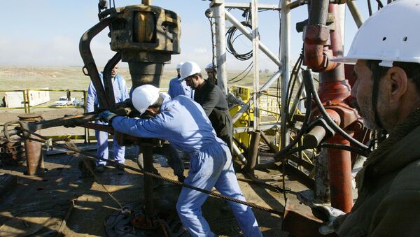 Iraqi workers pump oil at the Shirawa oilfield, where oil was first pumped in Iraq in 1927 - Sputnik International