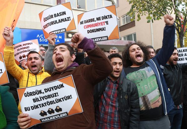 Participants hold placards reading 'Free press can't be silenced' (C) and 'Do not touch Cumhuriyet' (R) outside the headquarters of Turkish newspaper Cumhuriyet in Ankara on October 31, 2016, during a protest against the detention of the newspaper's editor-in-chief and a dozen journalists and executives. Participants hold placards reading 'Free press can't be silenced' (C) and 'Do not touch Cumhuriyet' (R) outside the headquarters of Turkish newspaper Cumhuriyet in Ankara on October 31, 2016, during a protest against the detention of the newspaper's editor-in-chief and a dozen journalists and executives. - Sputnik International