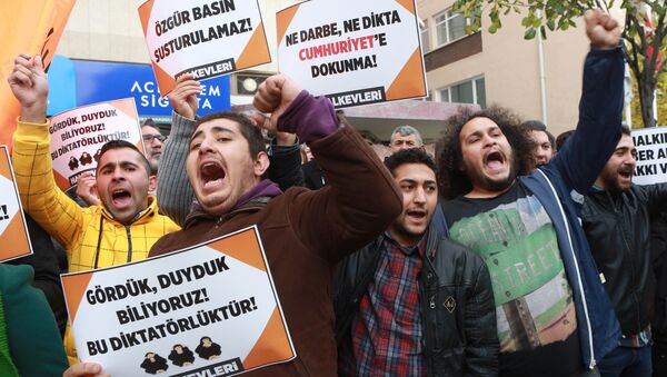 Participants hold placards reading 'Free press can't be silenced' (C) and 'Do not touch Cumhuriyet' (R) outside the headquarters of Turkish newspaper Cumhuriyet in Ankara on October 31, 2016, during a protest against the detention of the newspaper's editor-in-chief and a dozen journalists and executives - Sputnik International