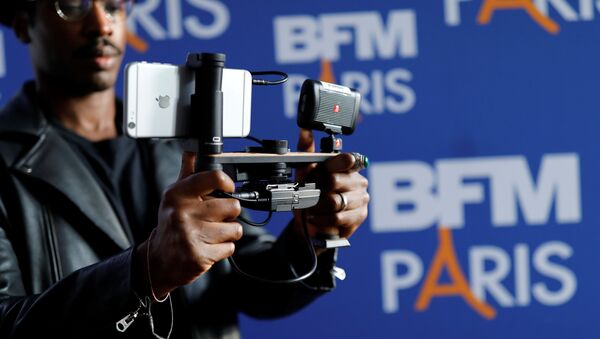 A video journalist uses an Apple iPhone 7 Plus smart phone to film during a press conference for the launching of the news channel, BFM Paris, in Paris, France, October 13, 2016 - Sputnik International