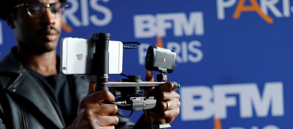 A video journalist uses an Apple iPhone 7 Plus smart phone to film during a press conference for the launching of the news channel, BFM Paris, in Paris, France, October 13, 2016 A video journalist uses an Apple iPhone 7 Plus smart phone to film during a press conference for the launching of the news channel, BFM Paris, in Paris, France, October 13, 2016 - Sputnik International