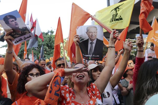 Supporters of Christian leader Michel Aoun hold his picture and Free Patriotic Movement, Lebanese flags and Hezbollah flag celebrate the election of the new President Michel Aoun, in Beirut, Lebanon, Monday, Oct. 31, 2016 - Sputnik International