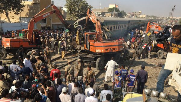 Rescuers workers use heavy machinery on the car of a train which crashed outside Karachi, Pakistan November 3, 2016 - Sputnik International