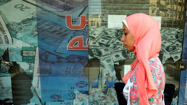 A woman walks past a money exchange bureau showing images of the U.S dollar with Egyptian pound and other foreign currency in Cairo, Egypt, October 12, 2016 - Sputnik International