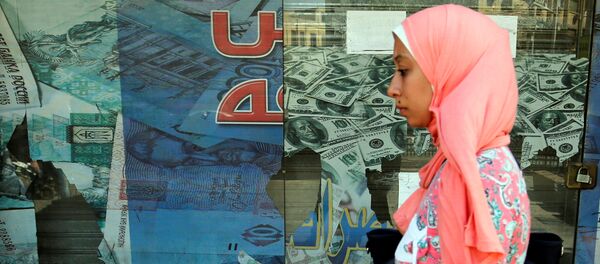 A woman walks past a money exchange bureau showing images of the U.S dollar with Egyptian pound and other foreign currency in Cairo, Egypt, October 12, 2016 A woman walks past a money exchange bureau showing images of the U.S dollar with Egyptian pound and other foreign currency in Cairo, Egypt, October 12, 2016 - Sputnik International