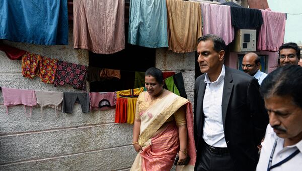 US Ambassador to India Richard R. Verma (centre R) walks through a slum in Bangalore on a visit to a drinking water project funded by USAID along with the local muncipal authority on November 3, 2015 - Sputnik International