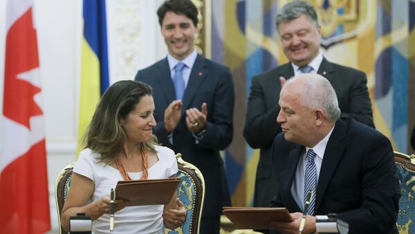 Canadian International Trade Minister Chrystia Freeland, foreground left, exchanges documents with First Vice Prime Minister, Minister of Economic Development and Trade of Ukraine Stepan Kubiv, foreground right, as Ukrainian President Petro Poroshenko, right, Canadian Prime Minister Justin Trudeau applaud during a signing ceremony in Kiev, Ukraine, Monday, July 11, 2016 - Sputnik International