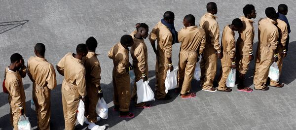 Migrants wait in line after disembarking from Spanish Navy cruiser Navarra in the Sicilian harbor of Catania, Italy, October 26, 2016. Migrants wait in line after disembarking from Spanish Navy cruiser Navarra in the Sicilian harbor of Catania, Italy, October 26, 2016. - Sputnik International